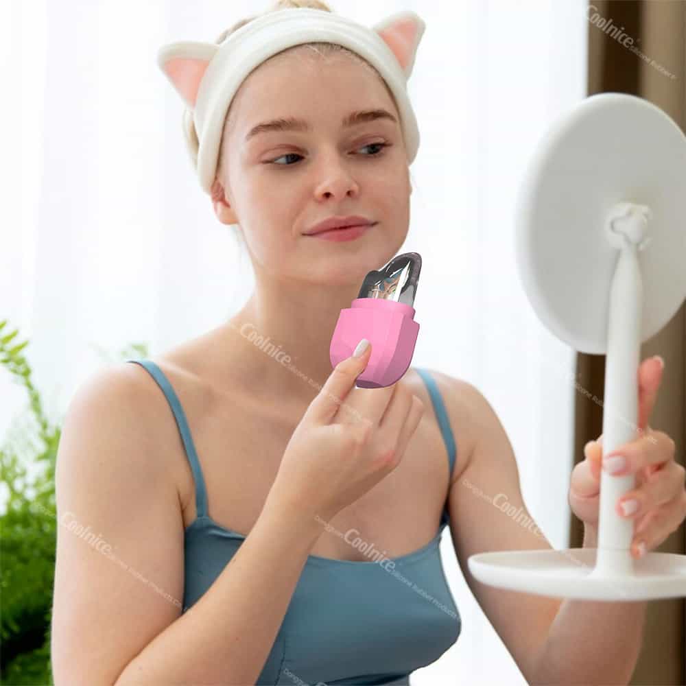 Woman using a pink diamond silicone ice roller on her face in front of a mirror