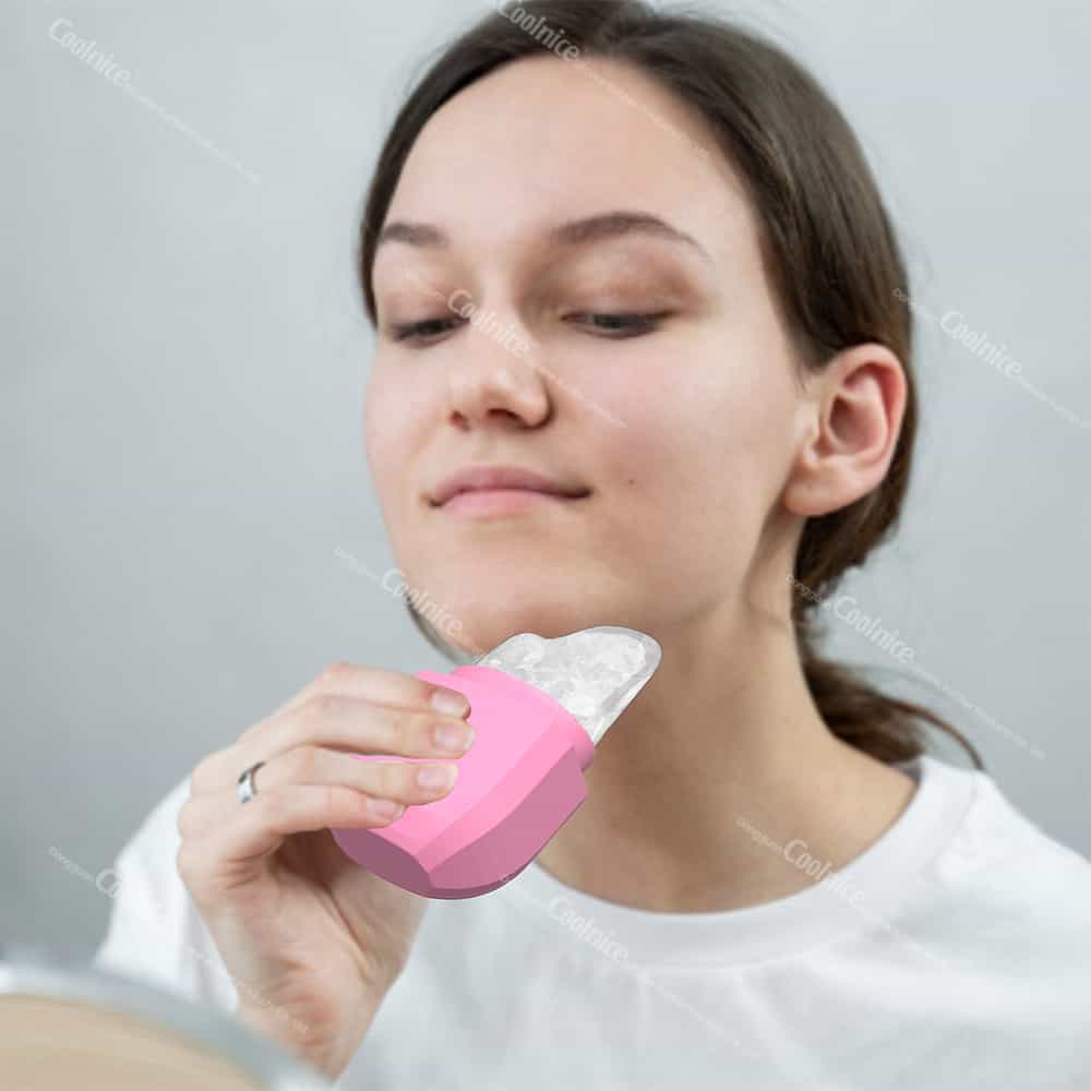 Woman applying a diamond-shaped silicone ice roller to her jawline