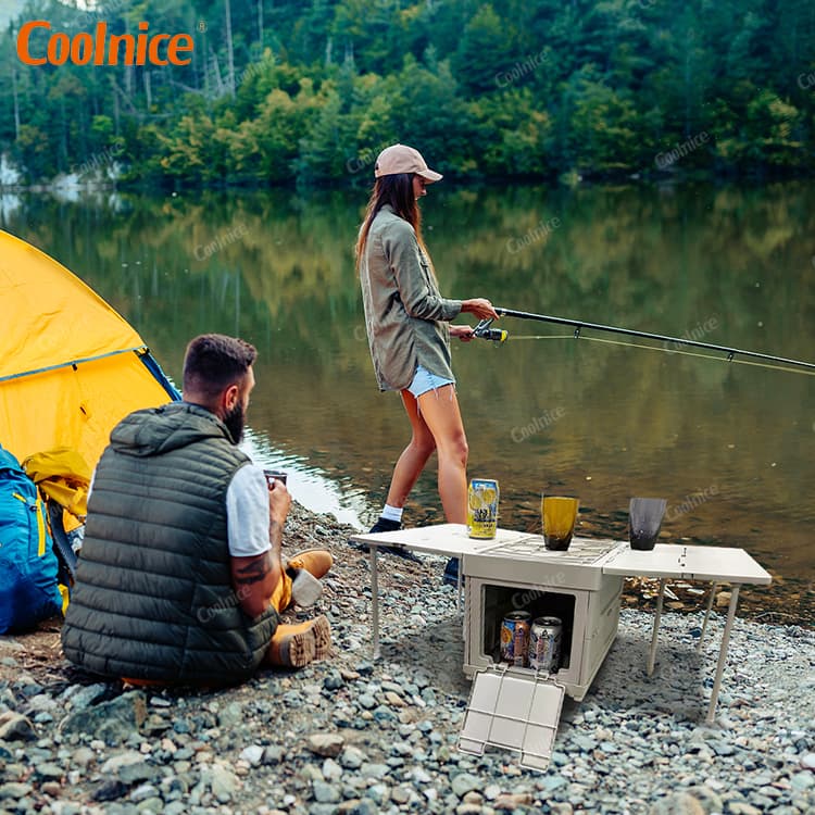 Outdoor camping storage box used as a portable table and cooler by the lake.