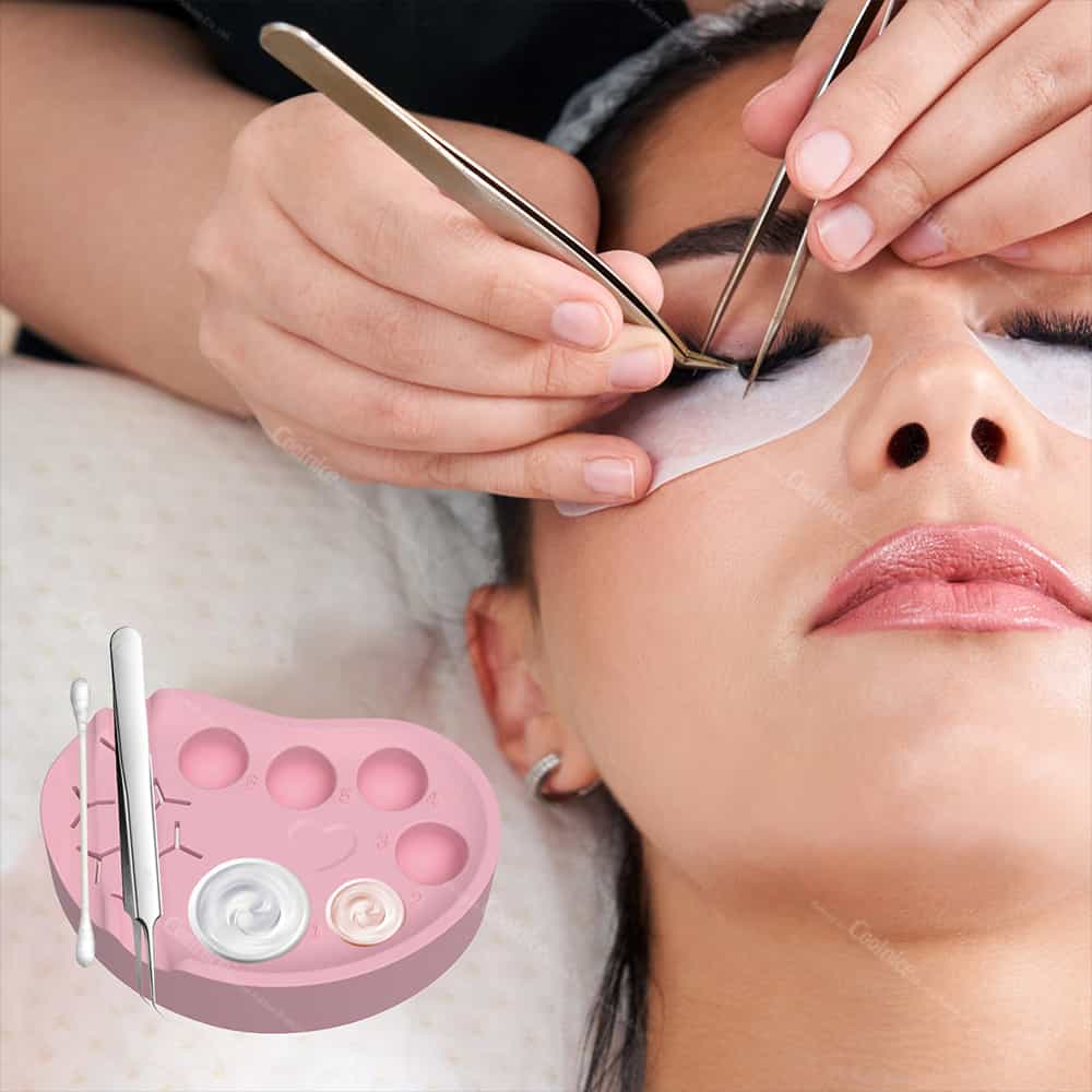Pink silicone palette used during eyelash extension application with glue wells and tweezer slots.