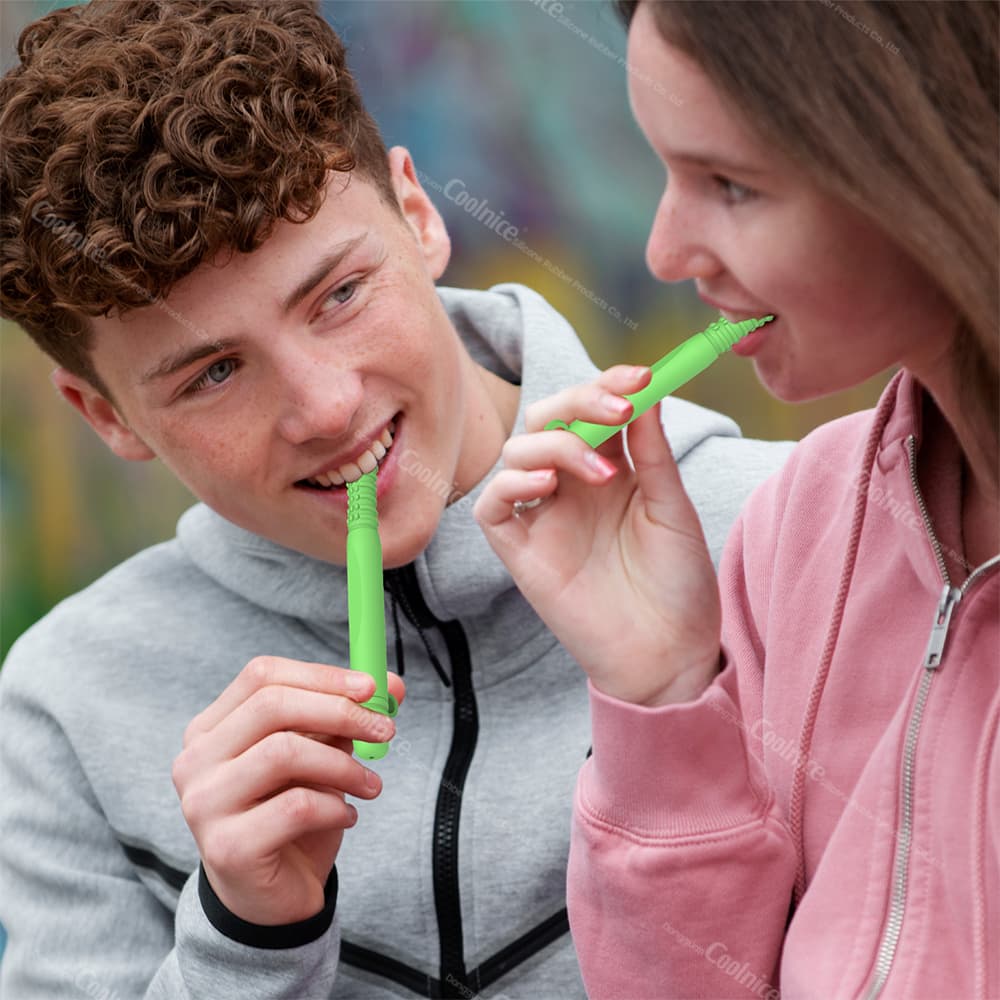 Two people using green silicone essential oil chewing sticks outdoors, demonstrating how to chew for relaxation and stress relief.