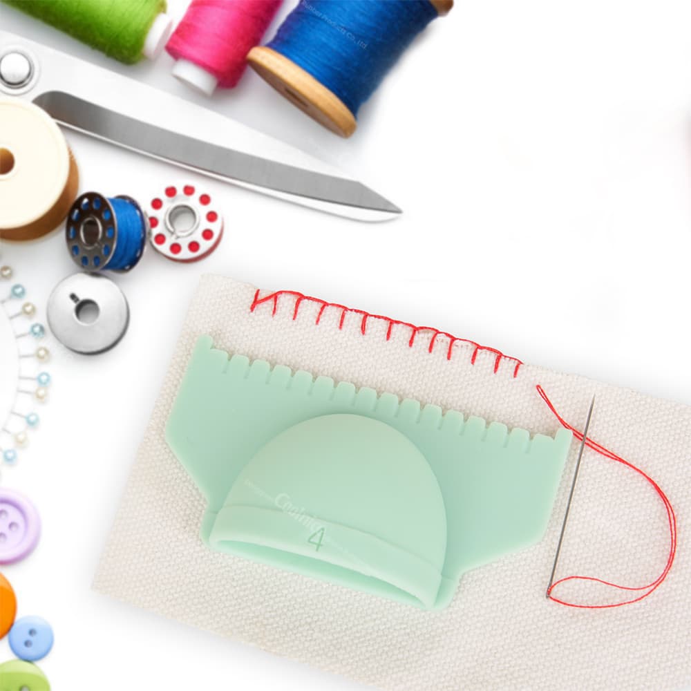Green sewing ruler template with a 4mm width for even stitching, with red thread on fabric, and a sewing needle in use.