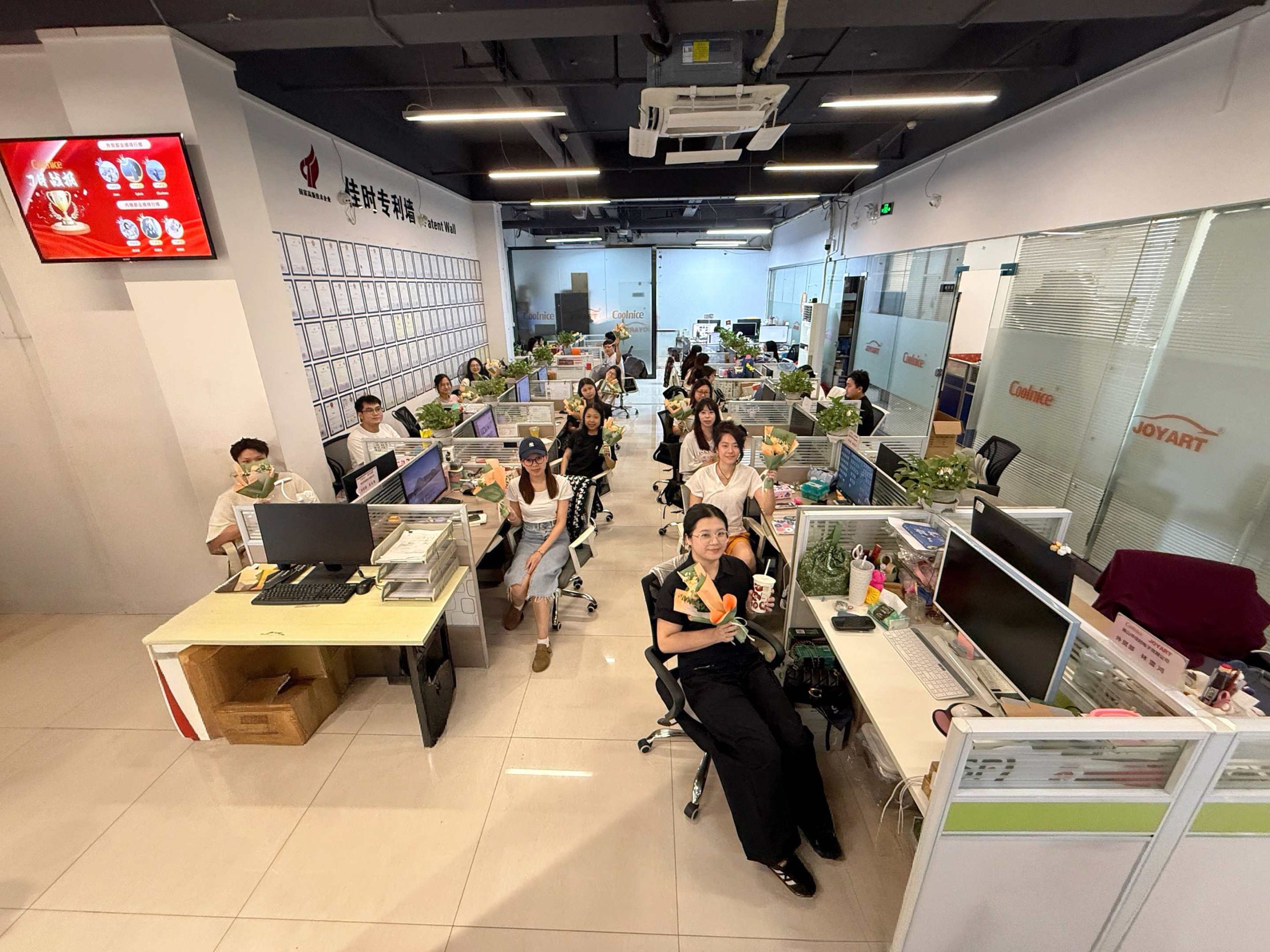 Coolnice employees celebrating Qixi Festival with flowers and smiles, showcasing team spirit and corporate care.