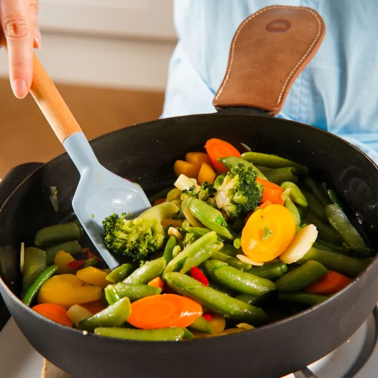 Is silicone better than plastic? Side-by-side of silicone spatula near hot pan vs plastic spatula on counter