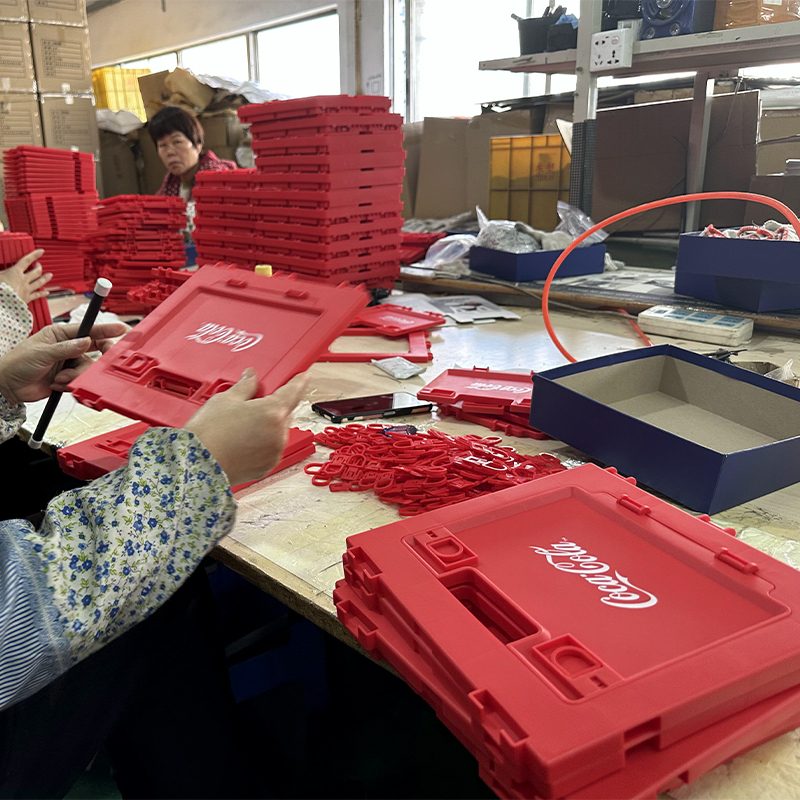 Assembly of Coca-Cola folding storage box panels in factory