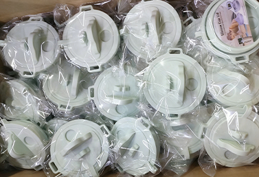 Bulk packed silicone tumbler lids in light green, wrapped securely for transport.