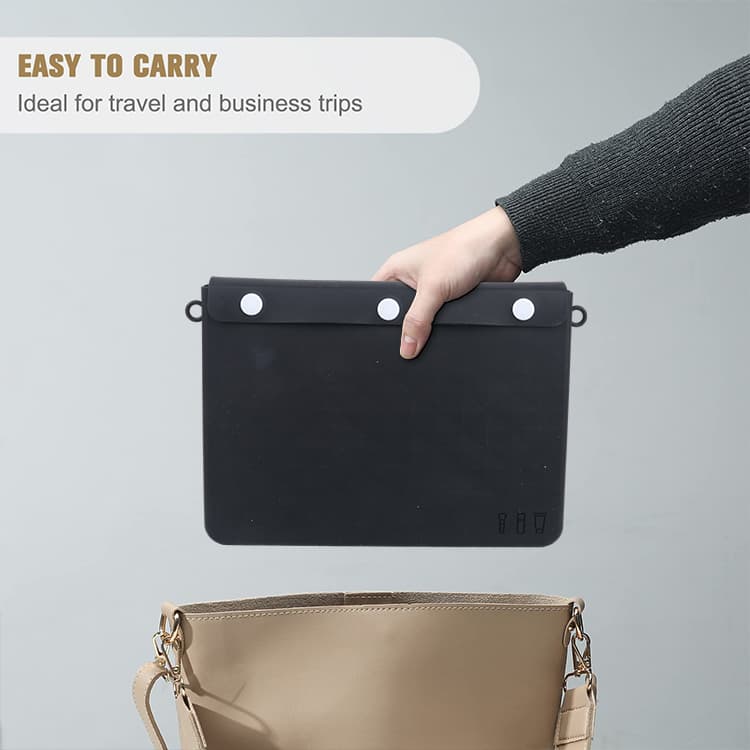 Black silicone cosmetic bag being placed into handbag