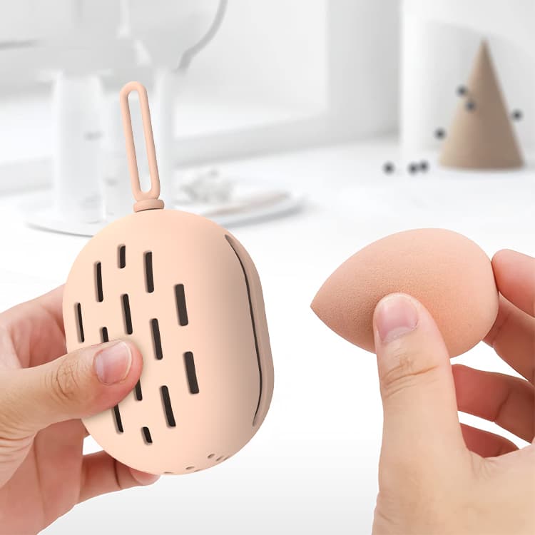 User inserting makeup sponge into soft silicone storage case