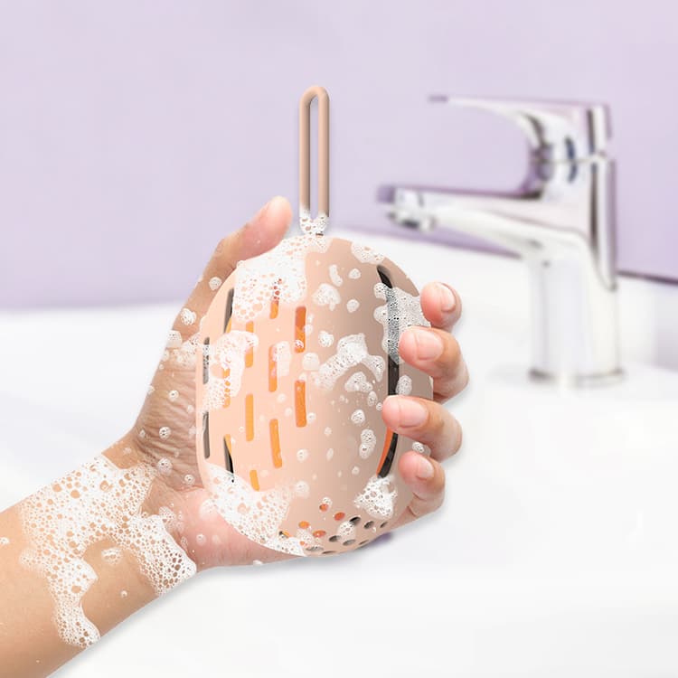 Silicone makeup sponge case being washed under soap and water