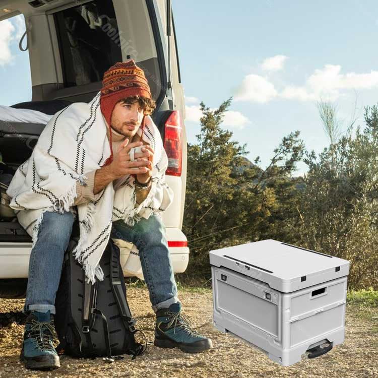 Camping storage box used beside SUV for outdoor travel and van camping.