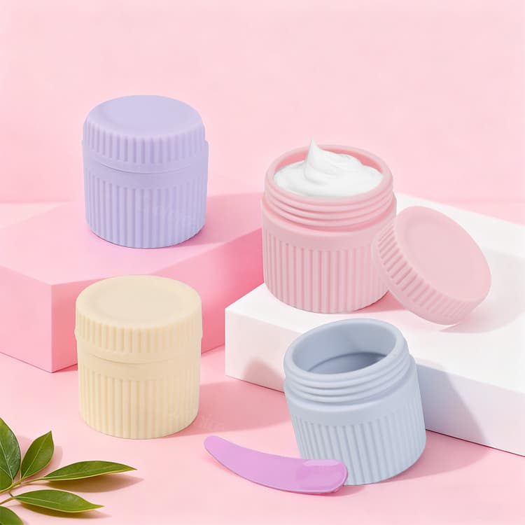 Pastel silicone cosmetic containers and spatula on pink background